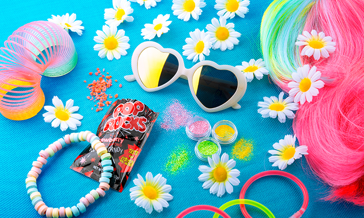 Heart-shaped sunglasses, Pop Rocks candy, candy bracelet, colorful Slinky, neon powders, and daisies.