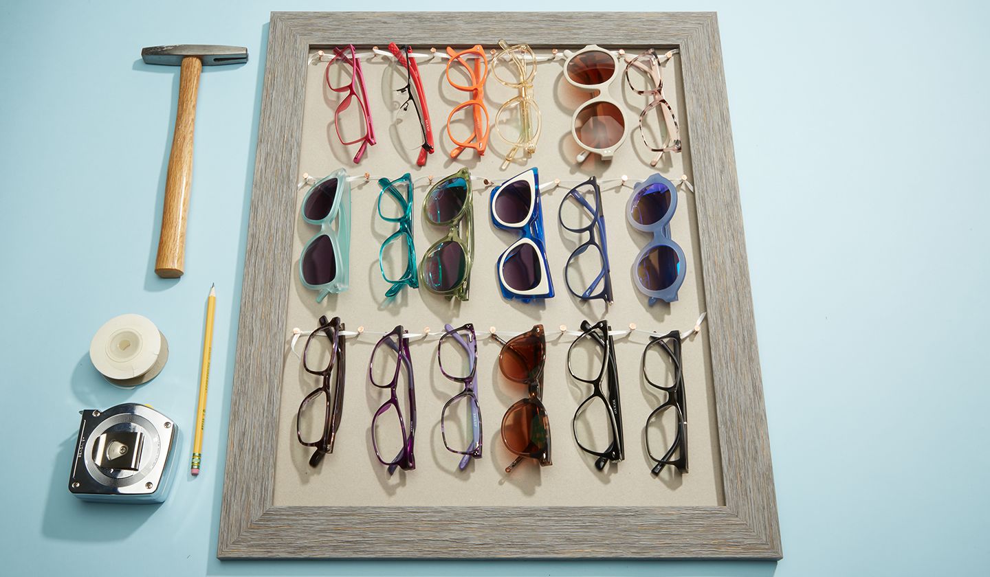 Various eyeglasses and sunglasses displayed in a wooden frame.