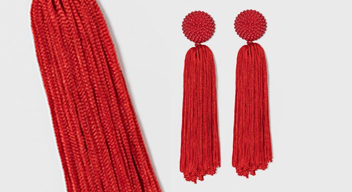 Red beaded tassel earrings with circular tops and long flowing strands.