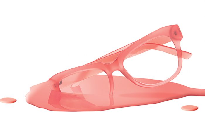 Red eyeglasses with liquid poured around and over them.