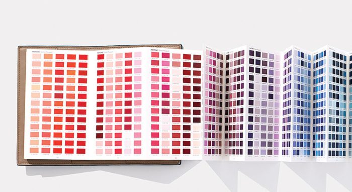 Pantone color swatches booklet with shades of red, pink, purple, and blue displayed in a grid format.