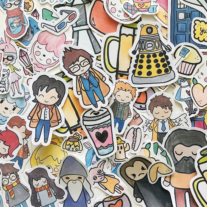 Assorted small, colorful cartoon character stickers, including cups, robots, and various people.
