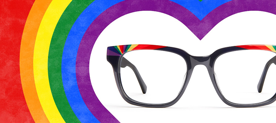 Black-rimmed eyeglasses with rainbow accents on the top of the frame, set against a rainbow heart background.