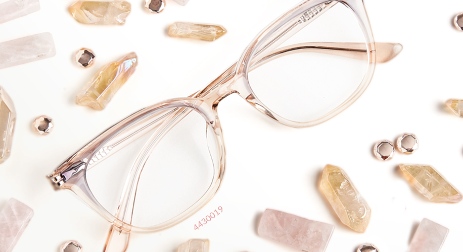 Clear eyeglasses with light pink frames, surrounded by crystals and gemstones. Text on frame: 4430019.