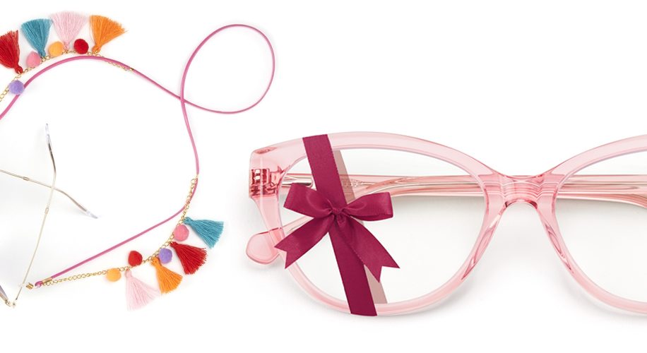 Pink eyeglass frame with a burgundy bow, accompanied by a colorful tassel eyeglass chain.
