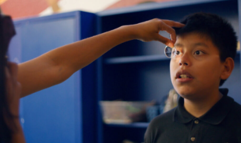 Zenni volunteer completes eye screening for young boy.
