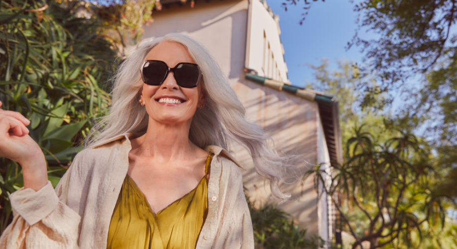 An older woman wears a large oversized pair of sunglasses.