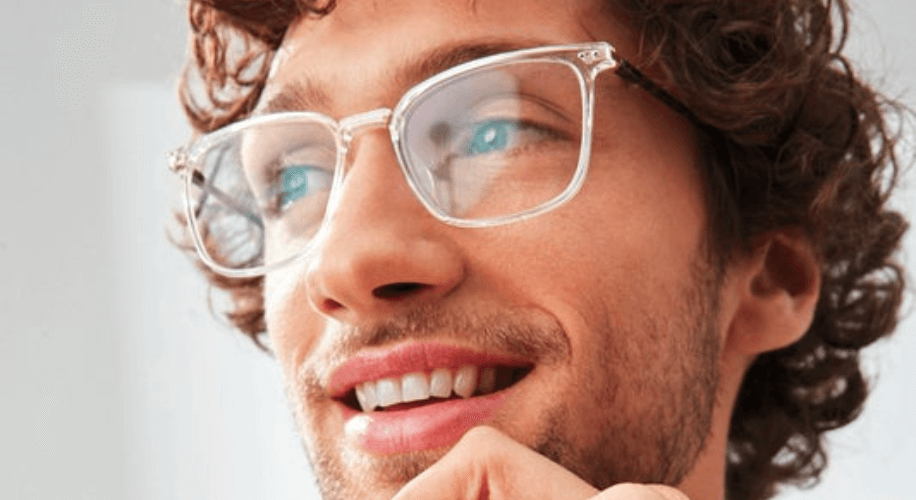 A close up of a man wearing clear glasses.