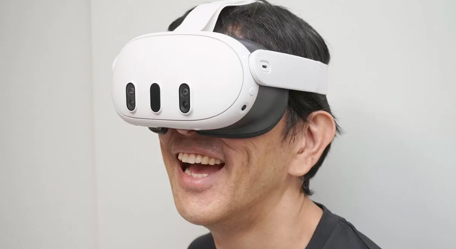 Man wearing white VR headset with built-in cameras and an adjustable strap.