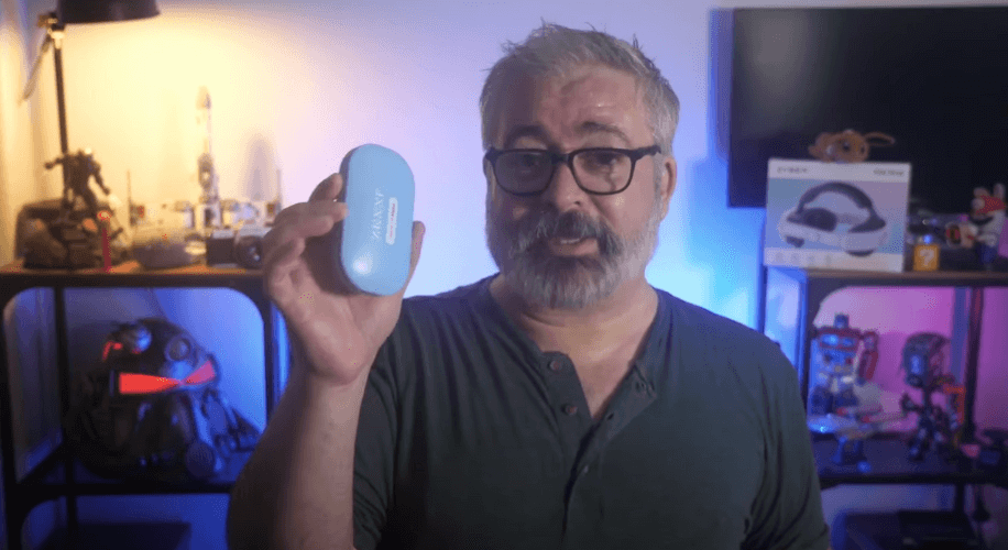 Man holding a blue Anker wireless charging case.