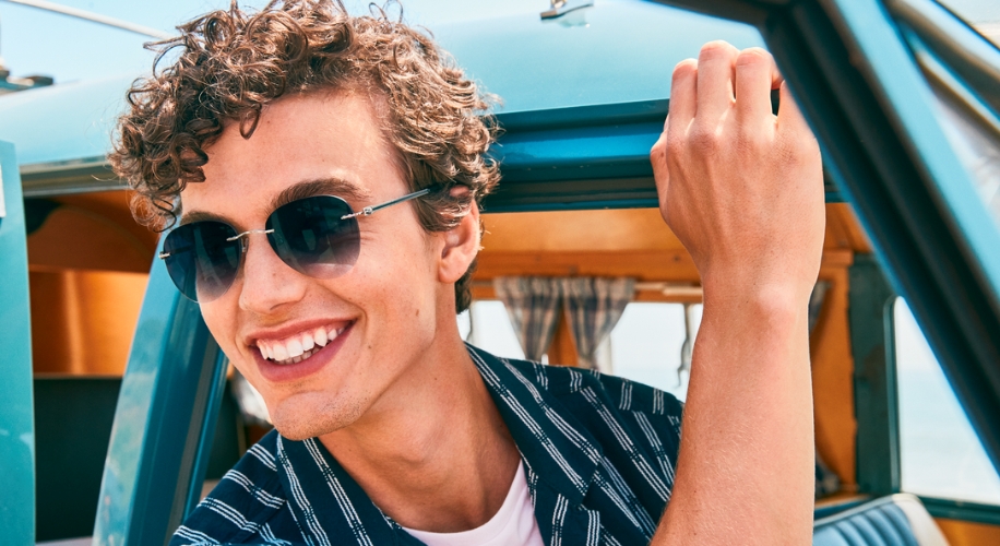 Man wearing dark sunglasses and smiling.