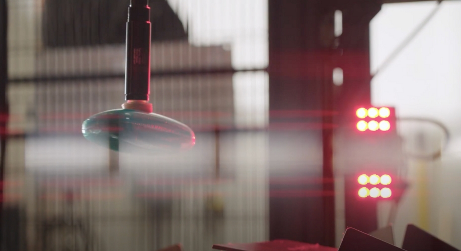 High-precision sensor in a manufacturing environment, surrounded by red and white LED lights.