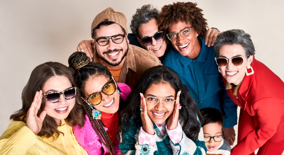Group of smiling people wearing various styles of eyeglasses and sunglasses.