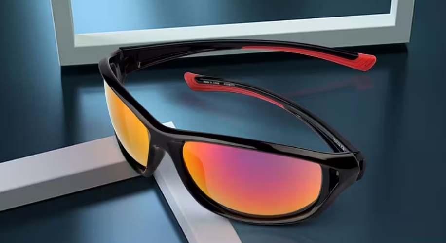 Sunglasses with black frame and red temples, featuring reflective orange lenses.