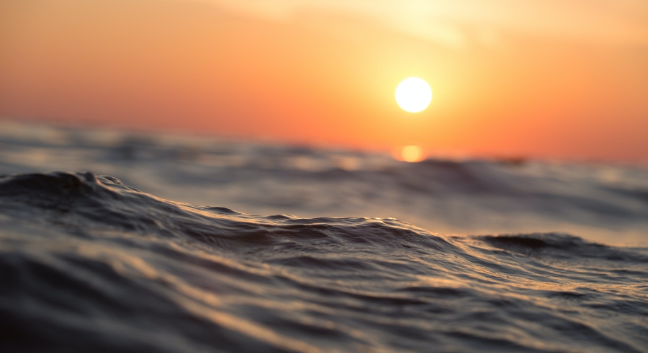 Ocean waves with a sunset in the background.