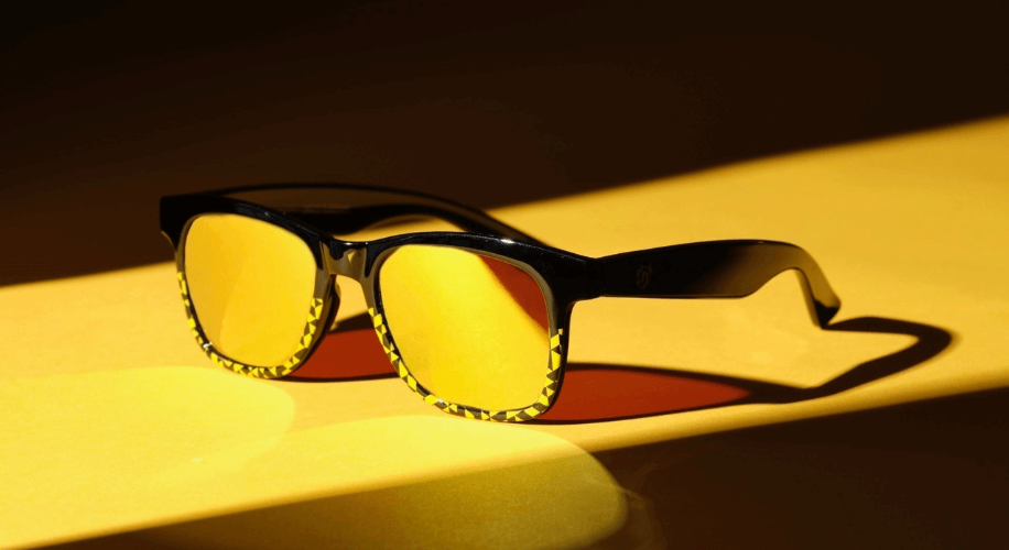 Black frame sunglasses with yellow-tinted lenses and yellow patterns on the edges.