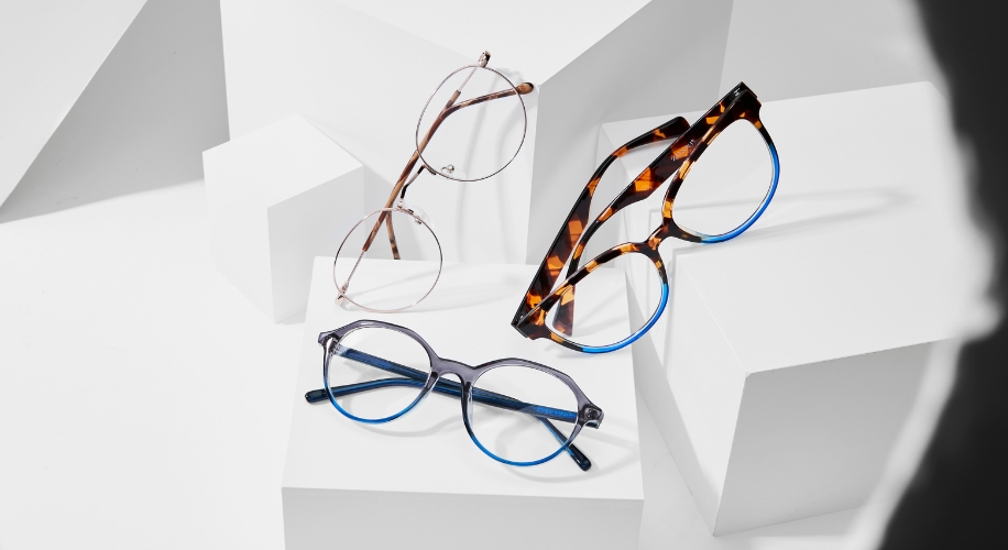 Three pairs of eyeglasses: round metal frames, tortoiseshell frames, and blue and black plastic frames.