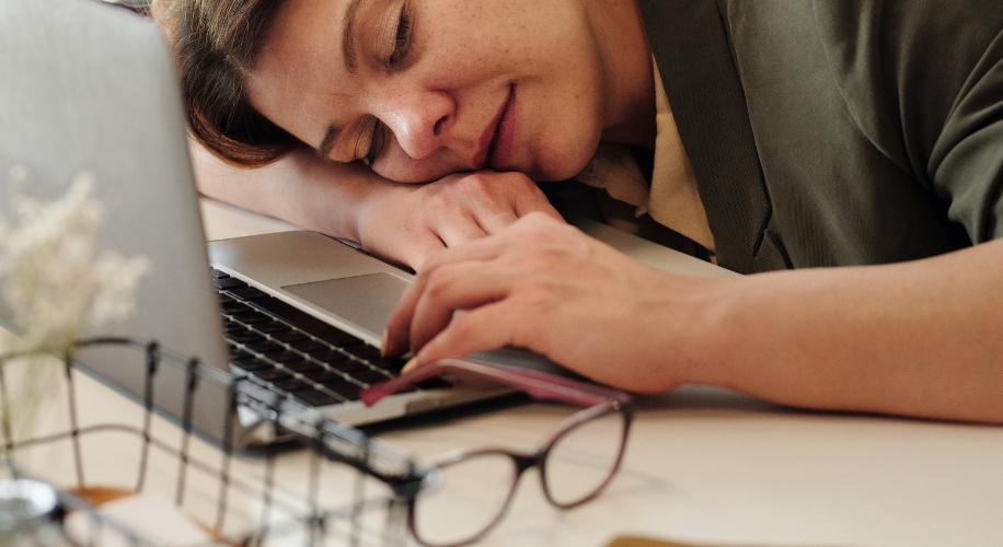 Person asleep on an open laptop keyboard.