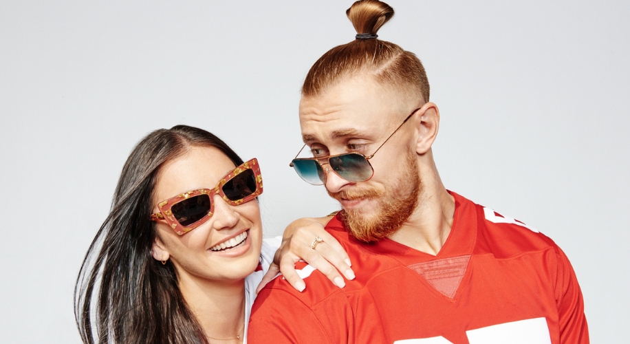 Two people wearing stylish sunglasses, one in a red sports jersey and the other with tortoiseshell frames.