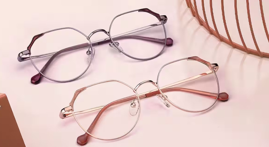 Two pairs of round metal eyeglasses, one in silver and the other in rose gold, with matching temple tips.