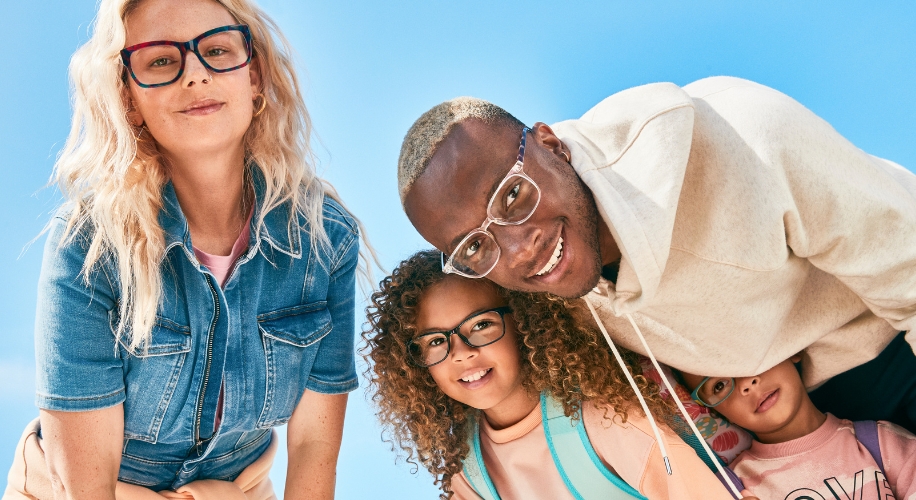 Group of people wearing various styles of eyeglasses, including black, clear, and red frames.