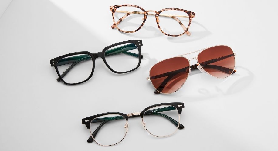 Four pairs of glasses: tortoiseshell, black rimmed, aviator sunglasses with brown lenses, and gold framed glasses.