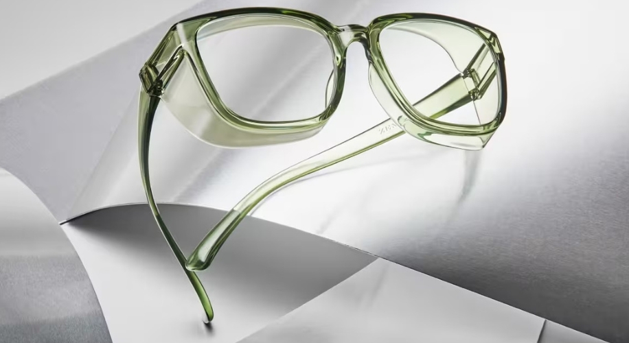 Green translucent eyeglasses on metallic and white background.