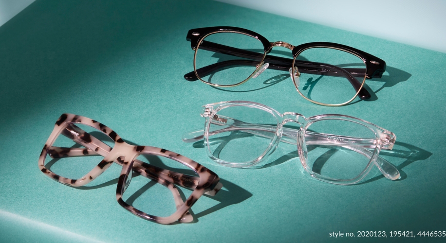 Three pairs of glasses on a teal surface. Styles: black frame, clear frame, and tortoiseshell frame. Style no. 2020123, 195421, 4446535.