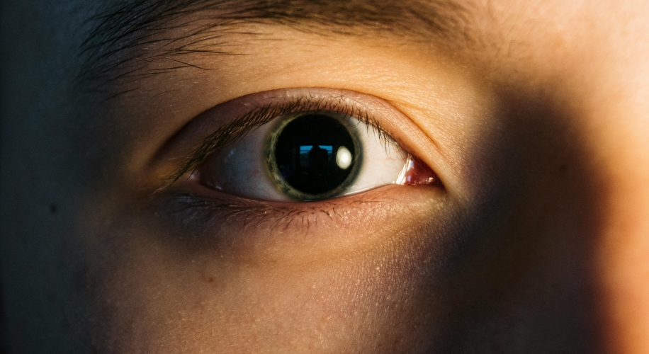 Close-up of a person&#039;s eye illuminated by light.