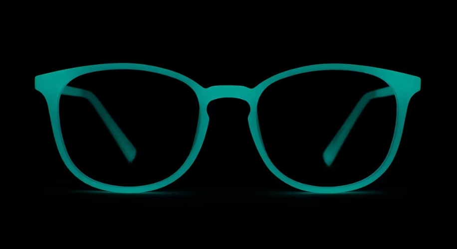 Glowing turquoise eyeglasses in the dark.