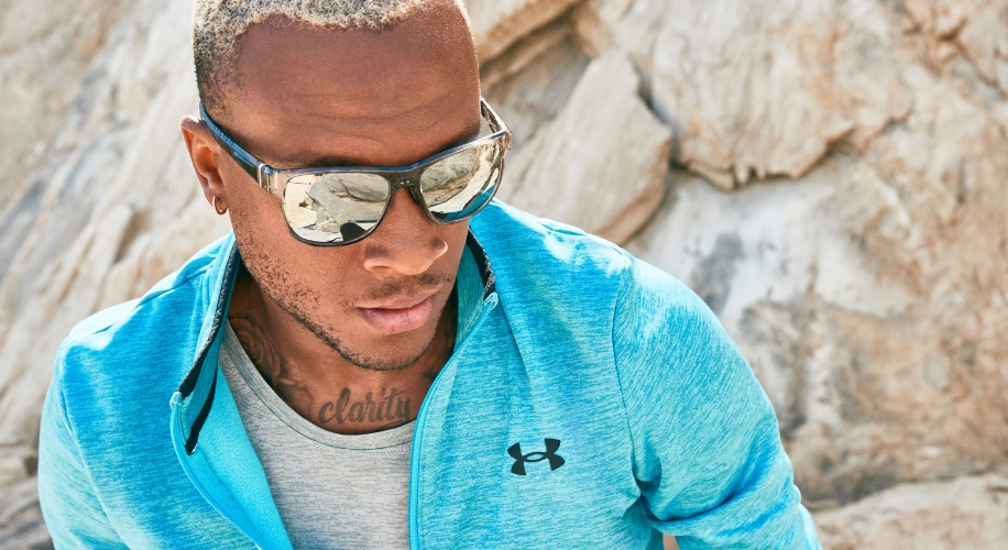 Man wearing mirrored sunglasses and a light blue Under Armour zip-up jacket.