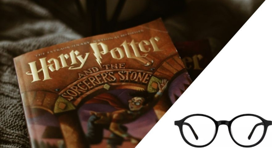 Harry Potter and the Sorcerer&#039;s Stone book next to round black glasses.