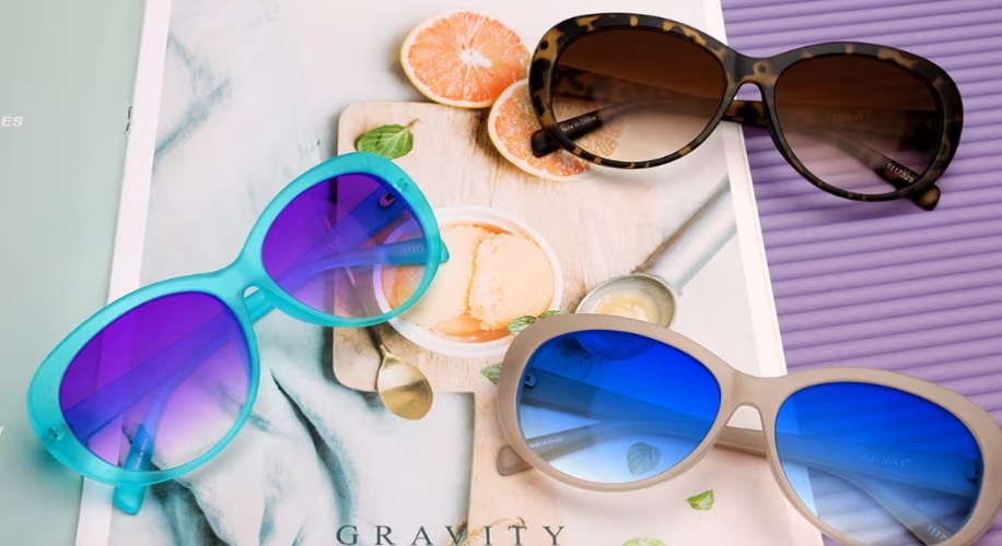 Three pairs of sunglasses: turquoise with purple lenses, brown tortoiseshell with brown lenses, and gray with blue lenses.
