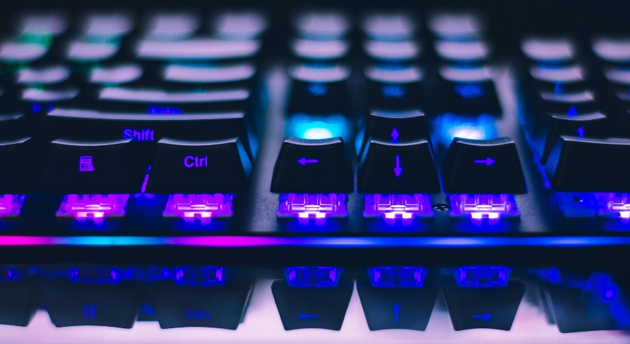 Close-up of a mechanical keyboard with purple LED backlighting under the keys. Ctrl and Shift keys visible.