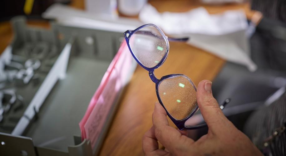 Eyeglasses with dusty lenses held in a person&#039;s hand.