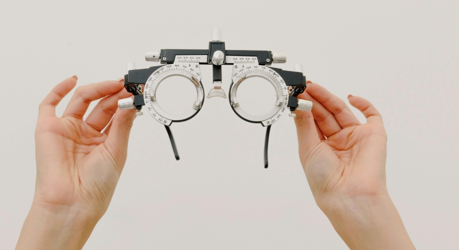 Trial lens frame for vision testing, held by both hands.