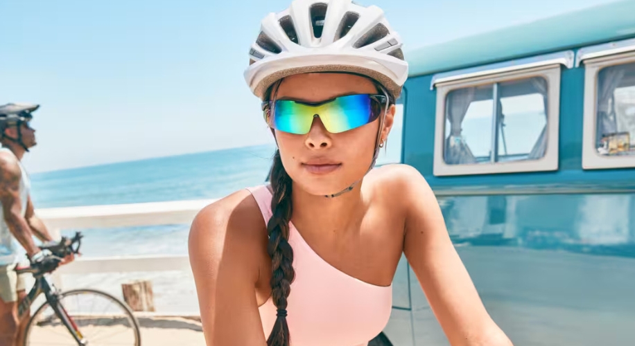 Woman wearing reflective sunglasses and white bicycle helmet.