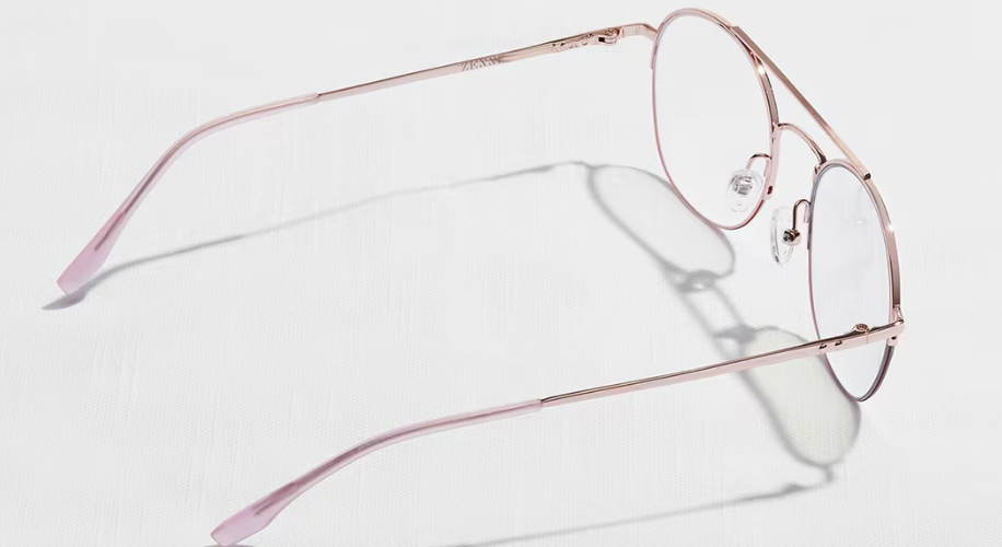 Pink metal round glasses with clear lenses and adjustable nose pads.