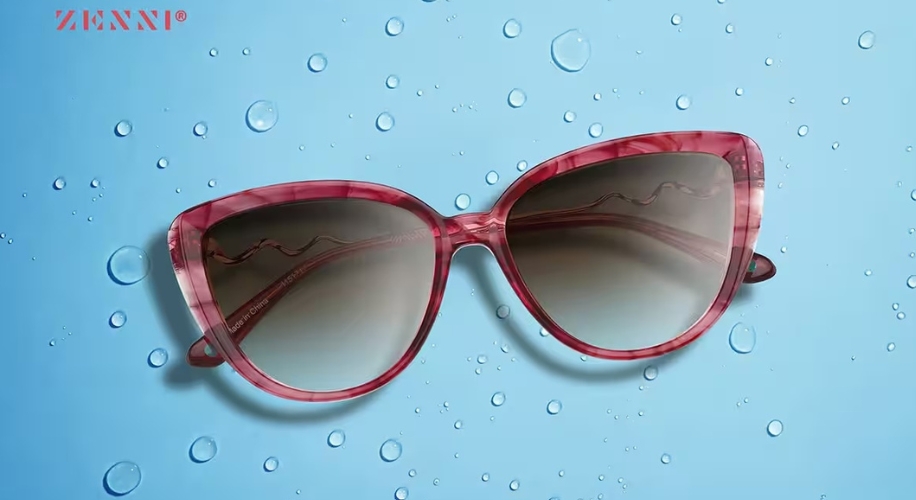 Zenni red cat-eye sunglasses with gradient lenses, set against a blue background with water droplets.