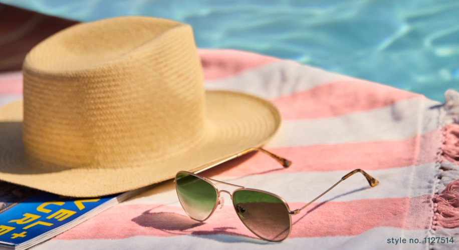 Straw sunhat and aviator sunglasses on a pink-striped towel near a pool. Text: &quot;style no. 1127514&quot;.