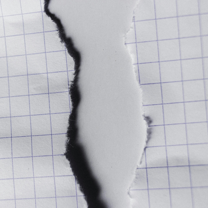 Torn graph paper with blue grid lines on both sides of the tear.