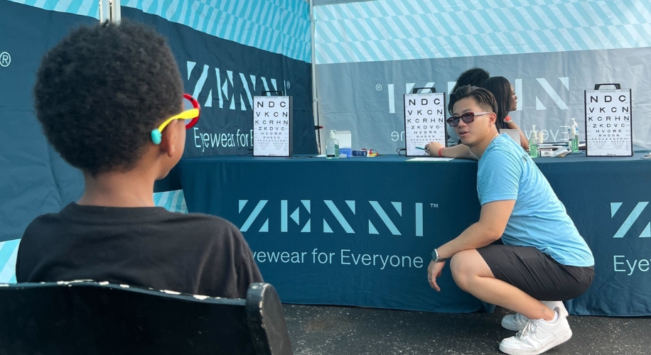 Optometrist pointing at an eye chart during a vision screening for children.