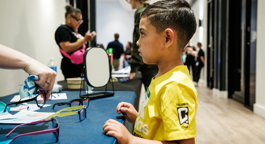 A child picking out their free Zenni eyewear at the vision screening event. Photo courtesy of Columbus Crew.
