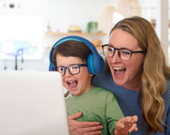 Image of a mom and her child wearing Zenni glasses, both watching content on a laptop computer.
