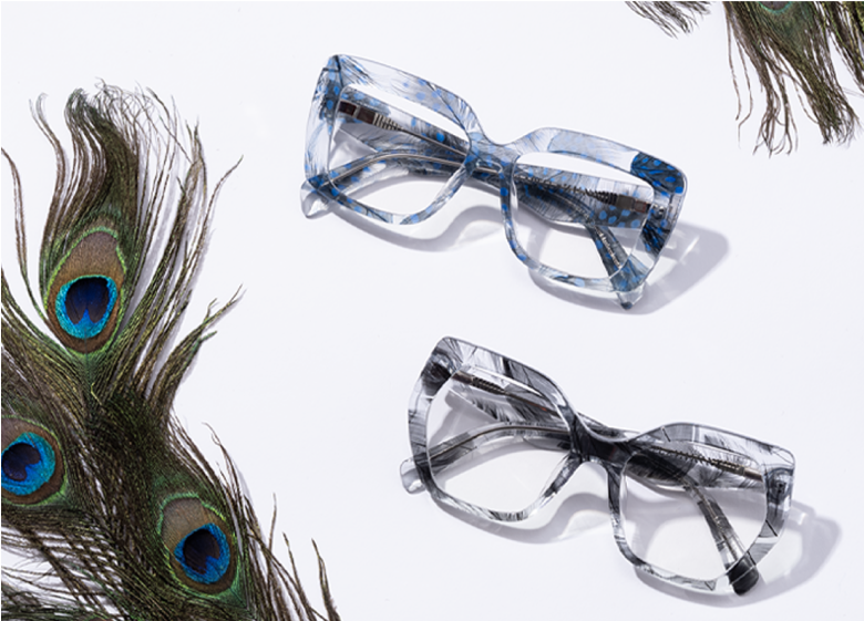 Peacock feathers next to blue feather-patterned transparent glasses and black feather-patterned transparent geometric glasses.