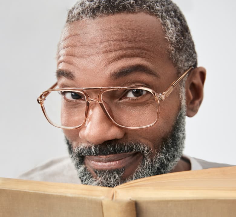 Man reading a book wearing stylish bifocal readers.