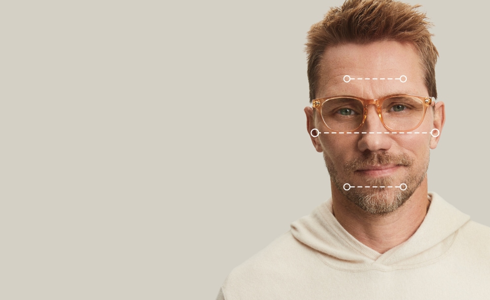 Diamond face shape. Light frames with rounded lens shapes bring balance and softness. Frames for diamond faces. Image of a man wearing Zenni glasses, with dotted lines over his face showing the various dimensions of his face.