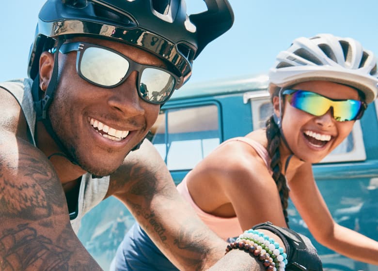 Image of a man and woman wearing Zenni sports sunglasses while riding bicycles.