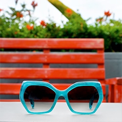 Mulholland geometric acetate sunglasses in aqua blue with gradient gray tint and Pico round acetate sunglasses in vibrant pink with gradient gray tint.